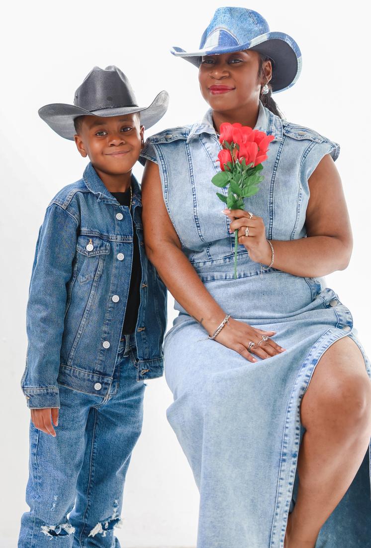 Raven and Khaza in matching denim and cowboy hats; she holds a bouquet of red roses.